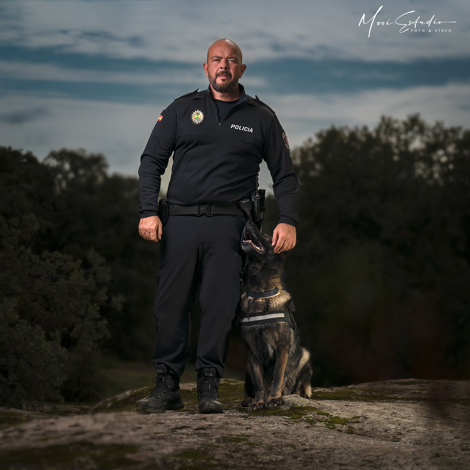 Retrato al aire libre de un agente de policía junto a su pastor alemán
